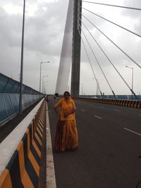 Rear view of woman on bridge against sky