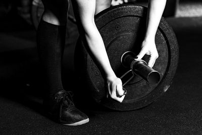 Cross training. female athlete changing weights on barbells