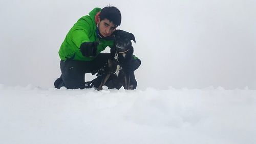 Full length of happy boy with horse in snow