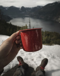 Midsection of person holding ice cream on mountain