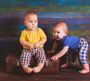 Portrait of cute boy sitting on floor