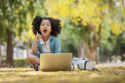 Boy looking away while sitting on camera