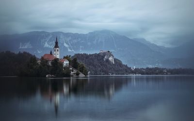 Scenic view of building by mountains against sky