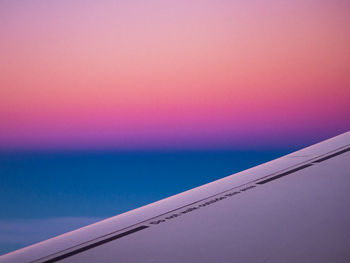 Airplane flying against sky during sunset