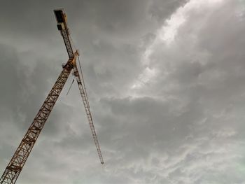 Low angle view of crane against sky