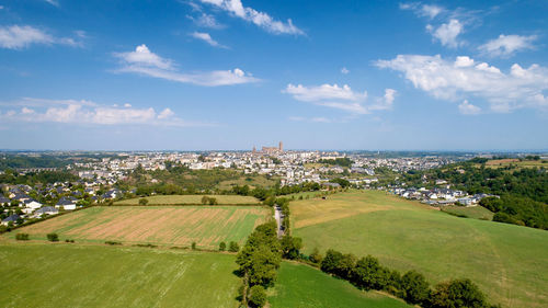 Scenic view of field against sky in city