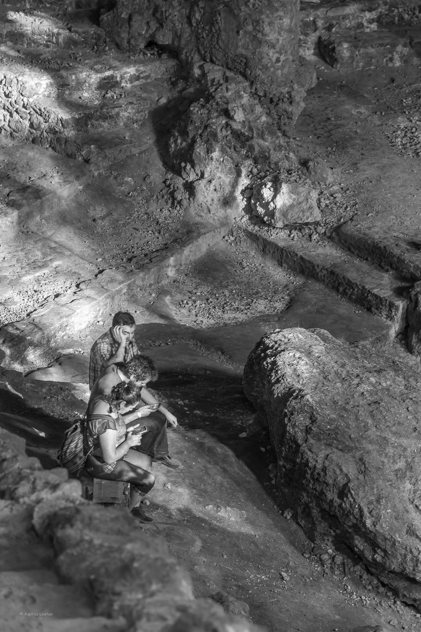 HIGH ANGLE VIEW OF MAN CLIMBING ON ROCKS