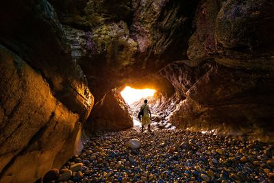 People standing on rock formation in cave