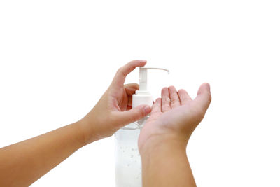 Close-up of hand holding water against white background