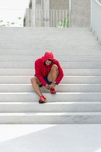 Full length of man tying shoelace on steps