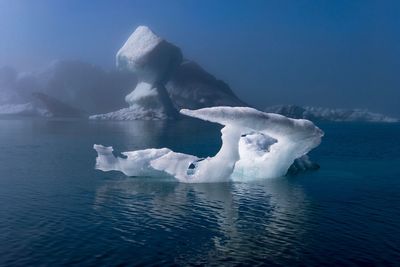 Ice floating on sea against sky during winter