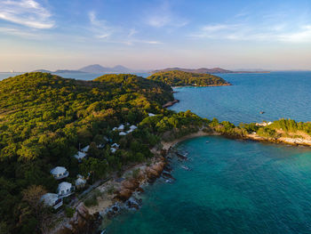 The top view of beautiful blue seashore and rocky on coast and white bungalow on the beach