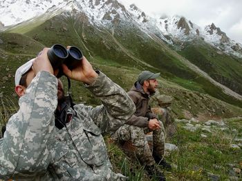 Rear view of friends on rock against mountains