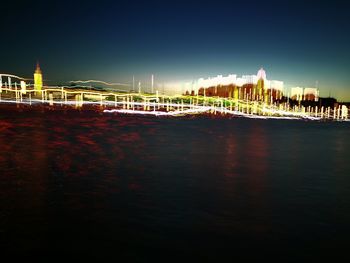 View of bridge over river at night