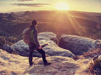 Professional photographer on location takes photos with mirror camera on peak of rock. dreamy land