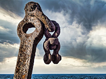 Close-up of rusty chain against sea