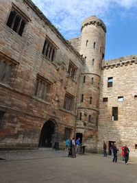 People in historic building against sky
