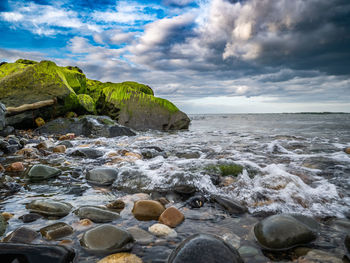 Rocks in sea against sky