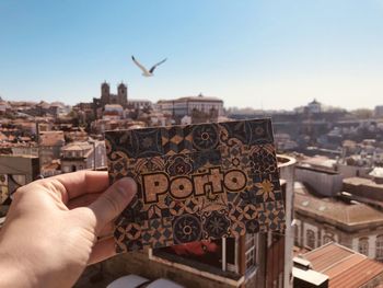 Low angle view of bird flying over buildings in city