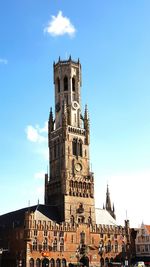 Low angle view of clock tower against cloudy sky