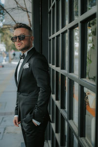 Portrait of young man standing against wall