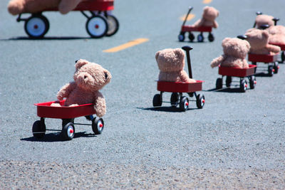Teddy bears in toy cars on road
