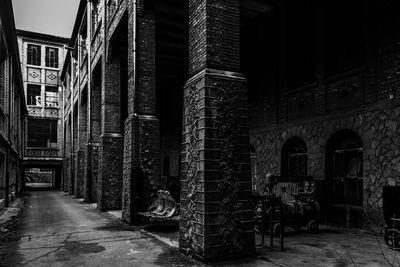 Empty alley amidst buildings at night