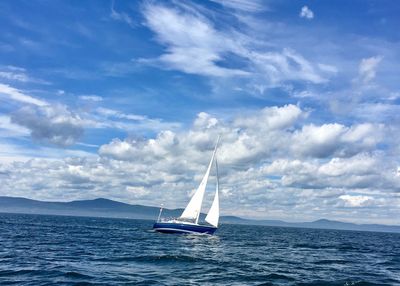 Ship sailing in sea against sky