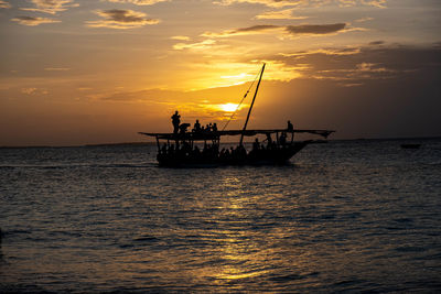 Silhouette boat in sea against sky during sunset