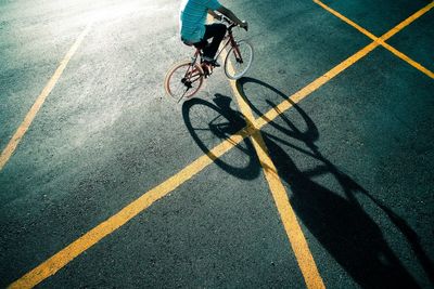 Low section of boy riding bicycle on road