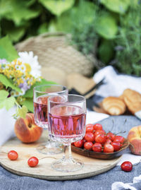 Picnic outdoors in lavender fields. rose wine in a glass, cherries and straw hat on blanket