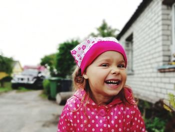 Portrait of cheerful girl wearing headscarf outdoors