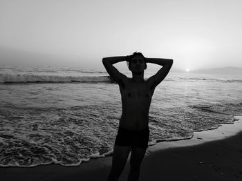 Man standing at beach against sky