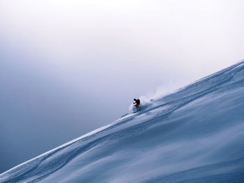 Man on snowcapped mountain against clear sky