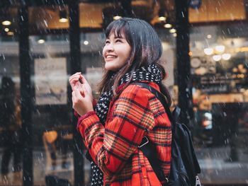 Smiling woman standing in city during winter