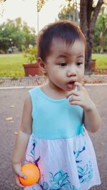 Cute girl looking away while standing on footpath