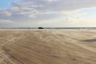 View of beach against cloudy sky