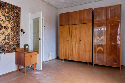 Old soviet  poor interior in khruschev house. aged sideboard.  shabby floor. tattered wallpaper. 