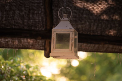 Low angle view of lantern hanging on wood