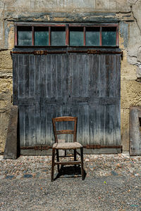 Empty chair against old building