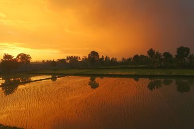 Scenic view of lake against orange sky