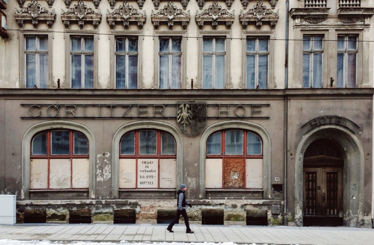 architecture, building exterior, built structure, window, building, arch, facade, city, men, day, full length, person, outdoors, residential building, entrance, walking, lifestyles, door