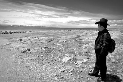 Full length of man standing on sea shore against sky