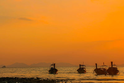 Silhouette sailboats in sea against sky during sunset