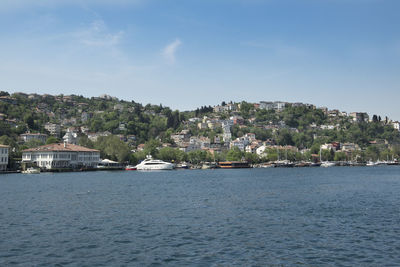 Buildings by sea against sky