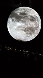 Low angle view of illuminated moon against sky at night