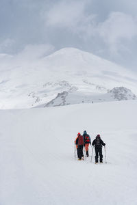 People skiing on snow covered landscape