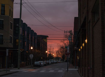 Street amidst buildings against sky at dusk