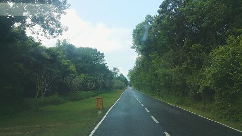 Road amidst trees against sky