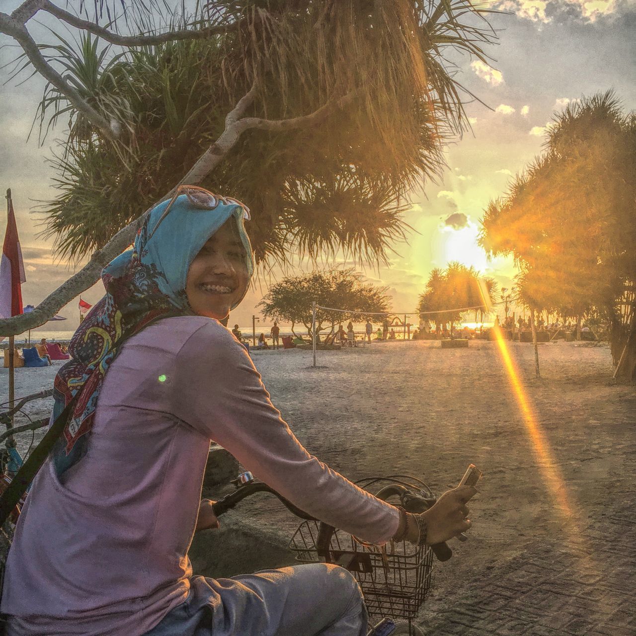 PORTRAIT OF GIRL SITTING ON BEACH AGAINST TREES